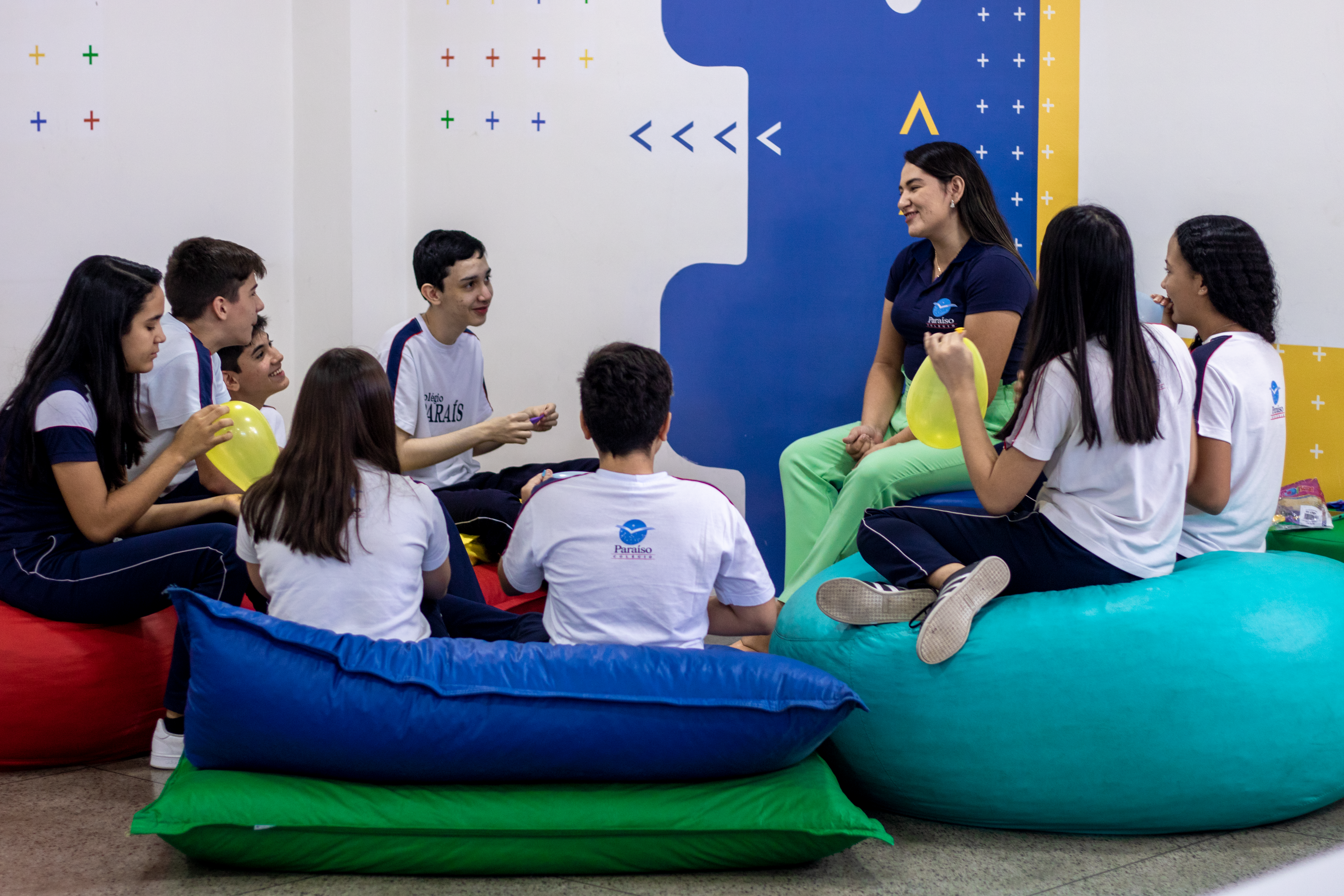 Professora e alunos senatados em almofadas